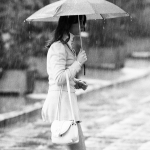 Femme avec parapluie sous la pluie