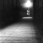 Couple sous un lampadaire sur un pont la nuit
