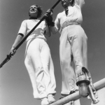 Deux adultes en tenue blanche à bord d'un bateau