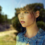 Portrait réfléchi d'une jeune femme à travers une fenêtre