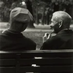 Deux hommes âgés discutant sur un banc dans un parc