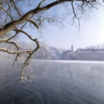 Paysage hivernal au bord de la rivière avec un bâtiment historique