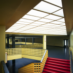 Escalier intérieur avec rambardes jaunes et marches rouges