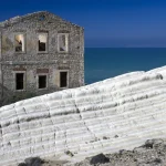 Vieille maison en pierre près de la mer avec formation rocheuse blanche