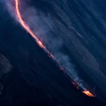 Voilier devant une éruption volcanique