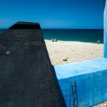 Plage avec structure en béton et mer bleue