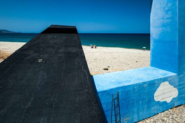 AKG4042590.webp Plage avec structure en béton et mer bleue – Image 1