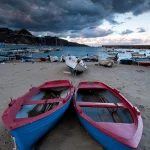Bateaux de pêche colorés sur une plage avant une tempête