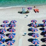 Plage avec parasols colorés et mer cristalline