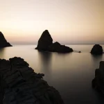 Coucher de soleil sur formations rocheuses en mer