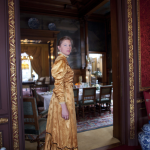 Femme en robe d'époque dans une pièce élégante