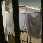 Linge séchant face à la plage par une fenêtre