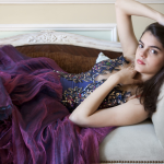 Femme allongée sur un canapé en robe élégante