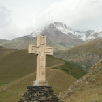 Croix en pierre de montagne avec vue sur des sommets enneigés