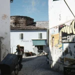 Rue pavée pittoresque avec un homme poussant une charrette