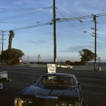 Voiture garée près de la plage avec panneau de fruits