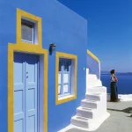 Maison bleue et personne regardant la mer à Santorin