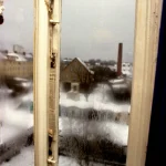 Vue hivernale par une fenêtre embuée