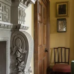 Décor intérieur avec cheminée sculptée et livres