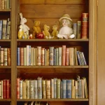 Étagère de livres avec peluches et poupée