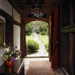 Vue sur un jardin depuis l'intérieur d'une maison historique