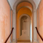 Escalier intérieur avec voûtes en arche et murs orangés