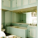 Salle de bain vintage avec armoire bleue et fauteuil fleuri
