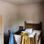 Chambre rustique avec lit en bois et linge coloré