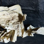 Vieux papier froissé sur fond de mur sombre