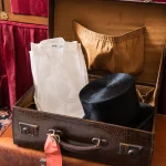 Valise vintage ouverte avec chapeau haut de forme et vêtements