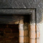 Détail d'une vieille cheminée en briques et bois