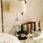 Table de chevet vintage avec lampe, téléphone rétro et livres
