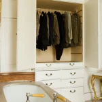 Armoire Ouverte et Baignoire Encadrée dans une Chambre Vintage