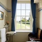 Salle de bain ancienne avec fenêtre et vue sur jardin