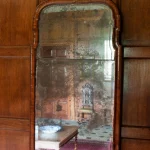 Miroir ancien reflétant une pièce meublée