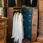 Valise ancienne utilisée comme penderie vintage