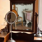Meuble de toilette ancien avec miroir et accessoires.