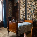 Chambre de style vintage avec lit en bois et tapisseries