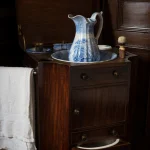 Évier et pichet en céramique sur meuble en bois ancien