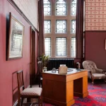 Bureau classique avec fenêtre vitrail et tapis rouge