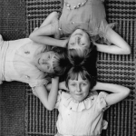 Trois filles allongées en cercle sur un tapis