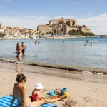 Plage méditerranéenne avec forteresse et famille