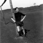 Footballer se reposant à côté d'un poteau de but