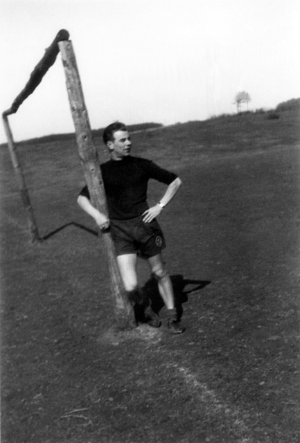 AKG4409334.webp Footballer se reposant à côté d'un poteau de but – Image 1