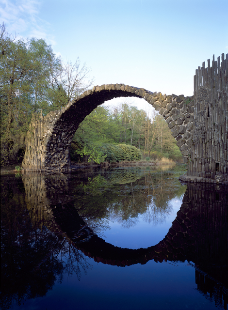 AKG448762.webp Pont de pierres en arc réfléchissant sur l'eau – Image 1