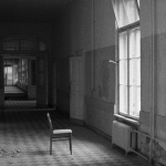 Fauteuil abandonné dans un couloir en noir et blanc