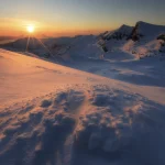 Lever de soleil sur un paysage montagneux enneigé