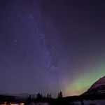 Nuit étoilée avec aurores boréales en montage enneigée