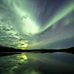 Aurore boréale lumineuse reflétée dans lac calme
