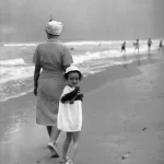 Femme et enfant marchant sur la plage